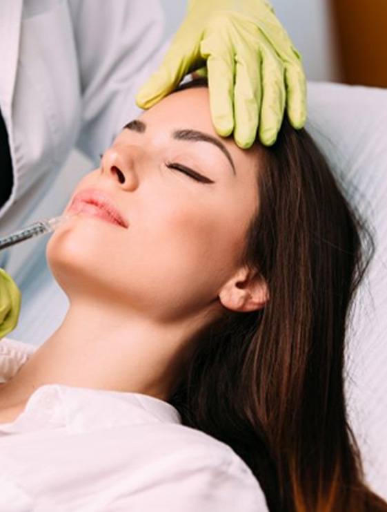 Woman relaxing while receiving dermal filler injection