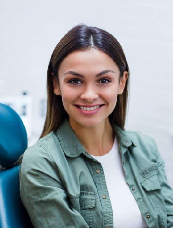 Woman smiling in dental chair at aesthetic dental office in Dallas