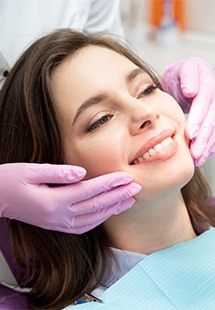 patient smiling while holding dental mirror