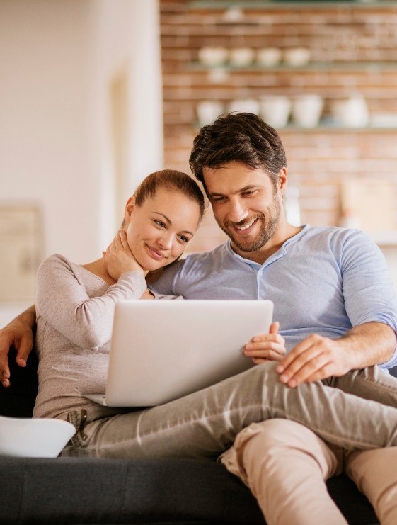 Man and woman looking at laptop for cosmetic dentist reviews in Dallas